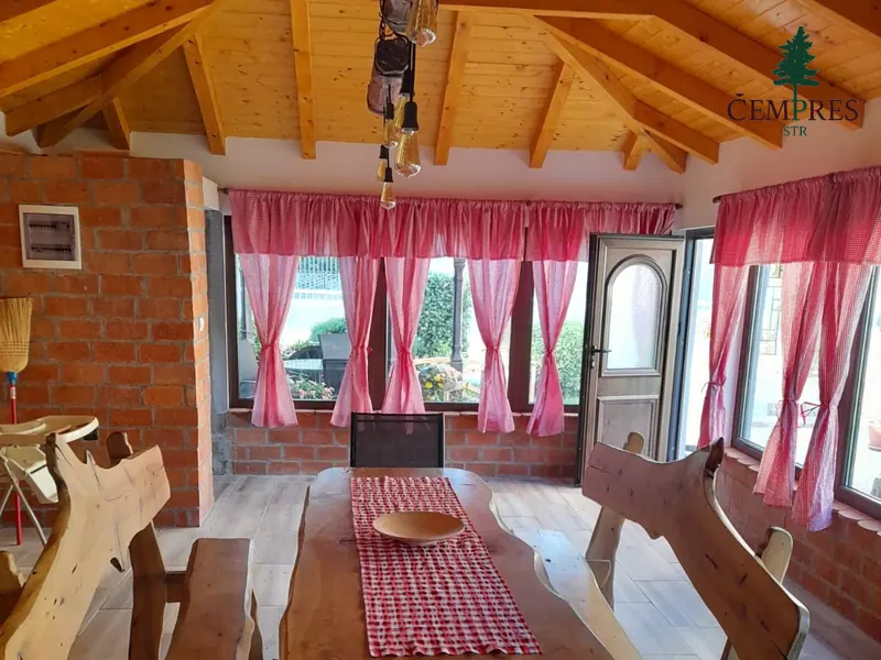 Trpezarija sa drvenim plafonom i stolom od masivnog drveta